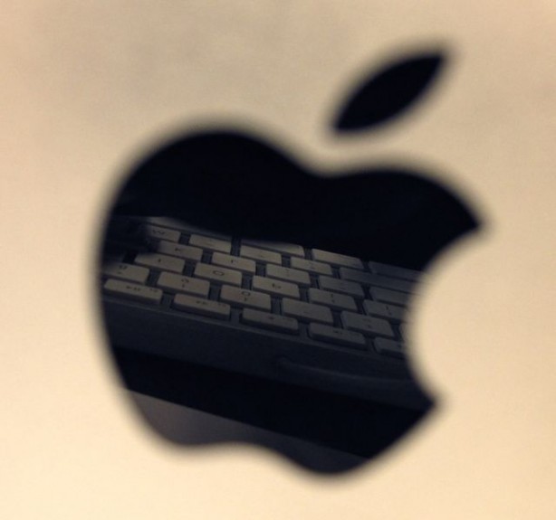Apple logo photograph with reflection of keyboard